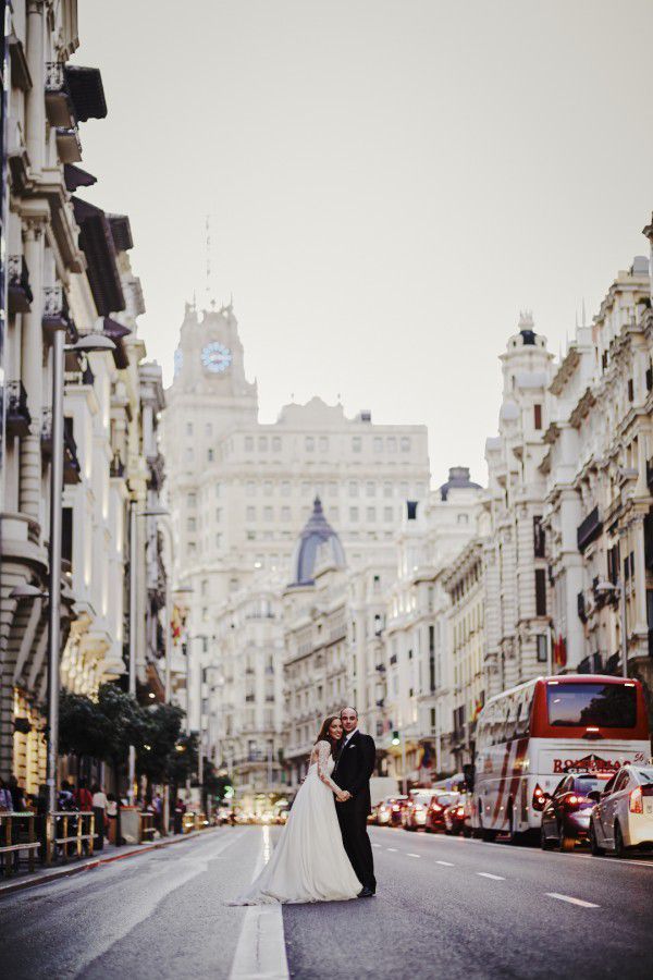 Pareja de recién casados paseando por la Gran Vía de Madrid en una boda urbana, elegante y moderna