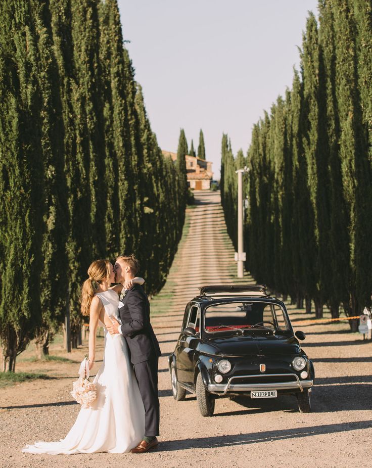 Novios besándose al atardecer entre viñedos en una boda íntima y elegante en la Toscana, Italia