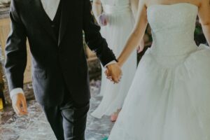 Novios cogidos de la mano en un elegante momento romántico de su boda en interior